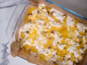 Butter on top of cake mix with pecans in a glass baking dish