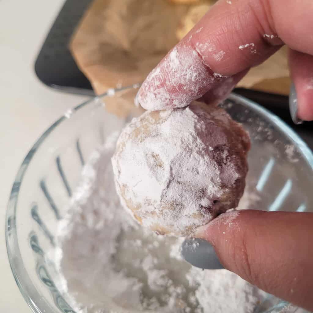 Close up of cookie rolled in powdered sugar