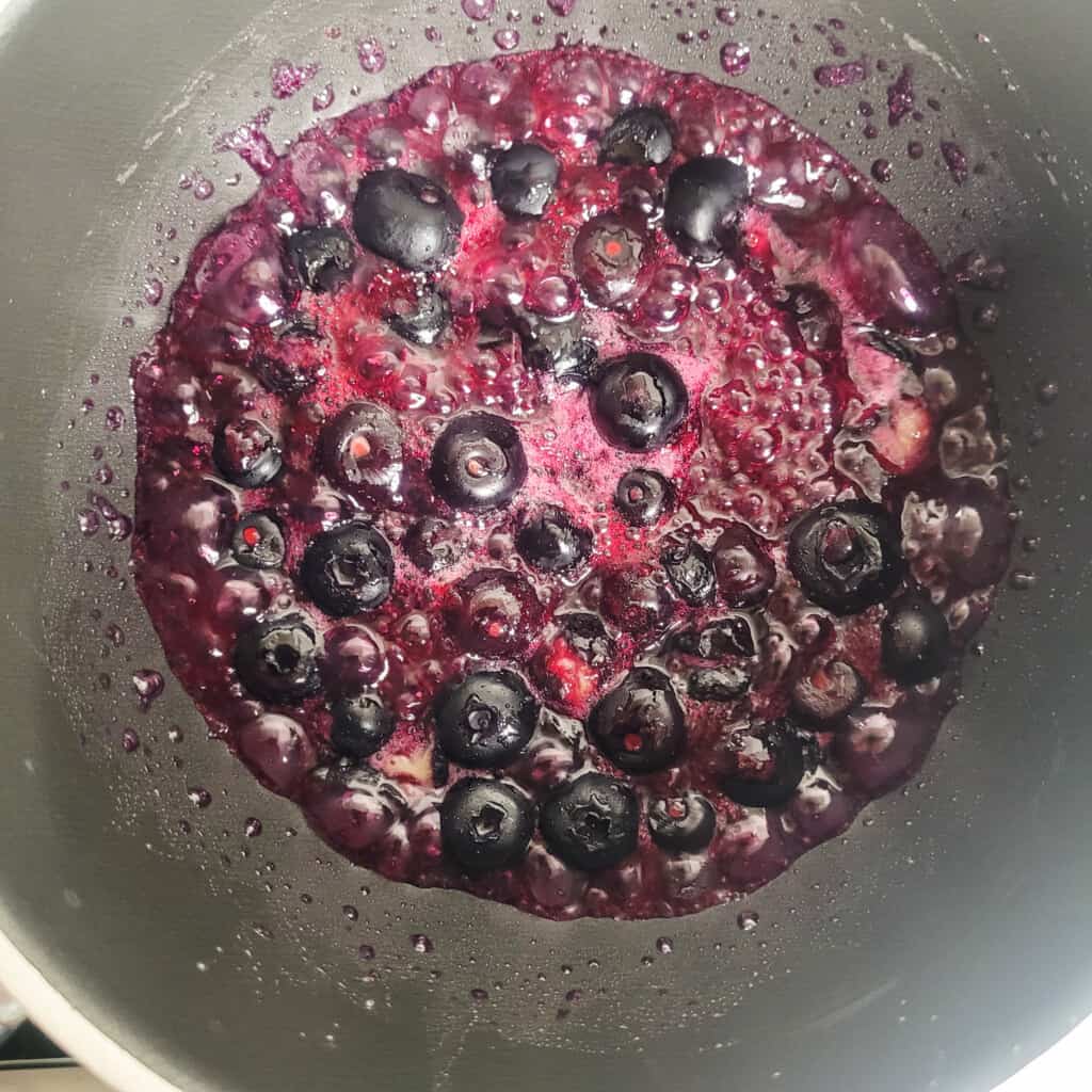 Blueberries with sugar boiling in a pot