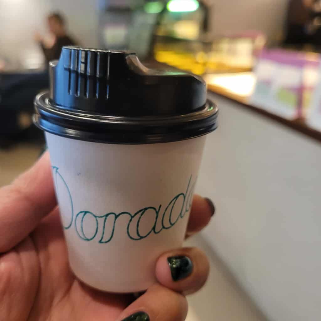 A small cortado in a to-go cup from Budapest cafe Dorado