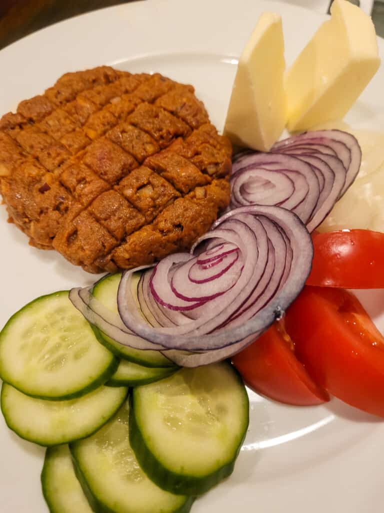 Plate of steak tartare next to vegetables