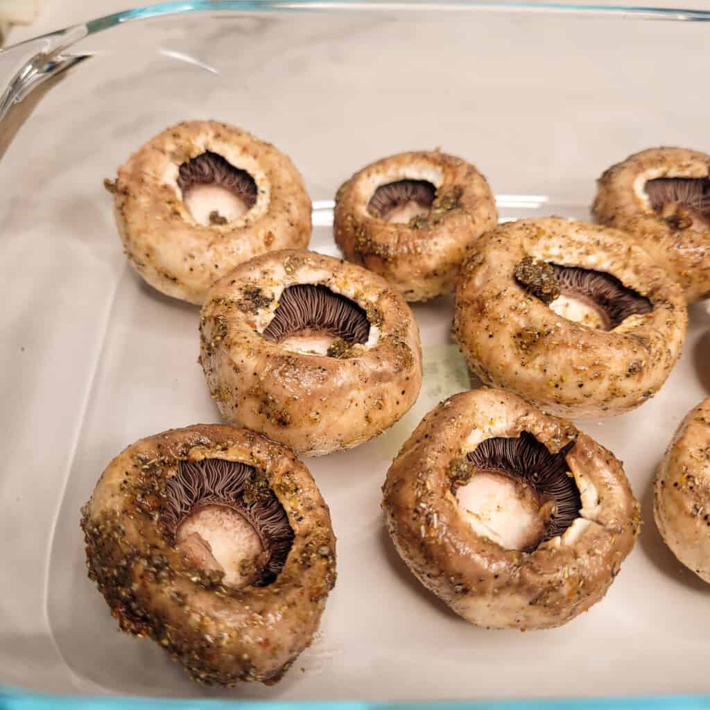Closeup of seasoned mushrooms for roasting in a pan