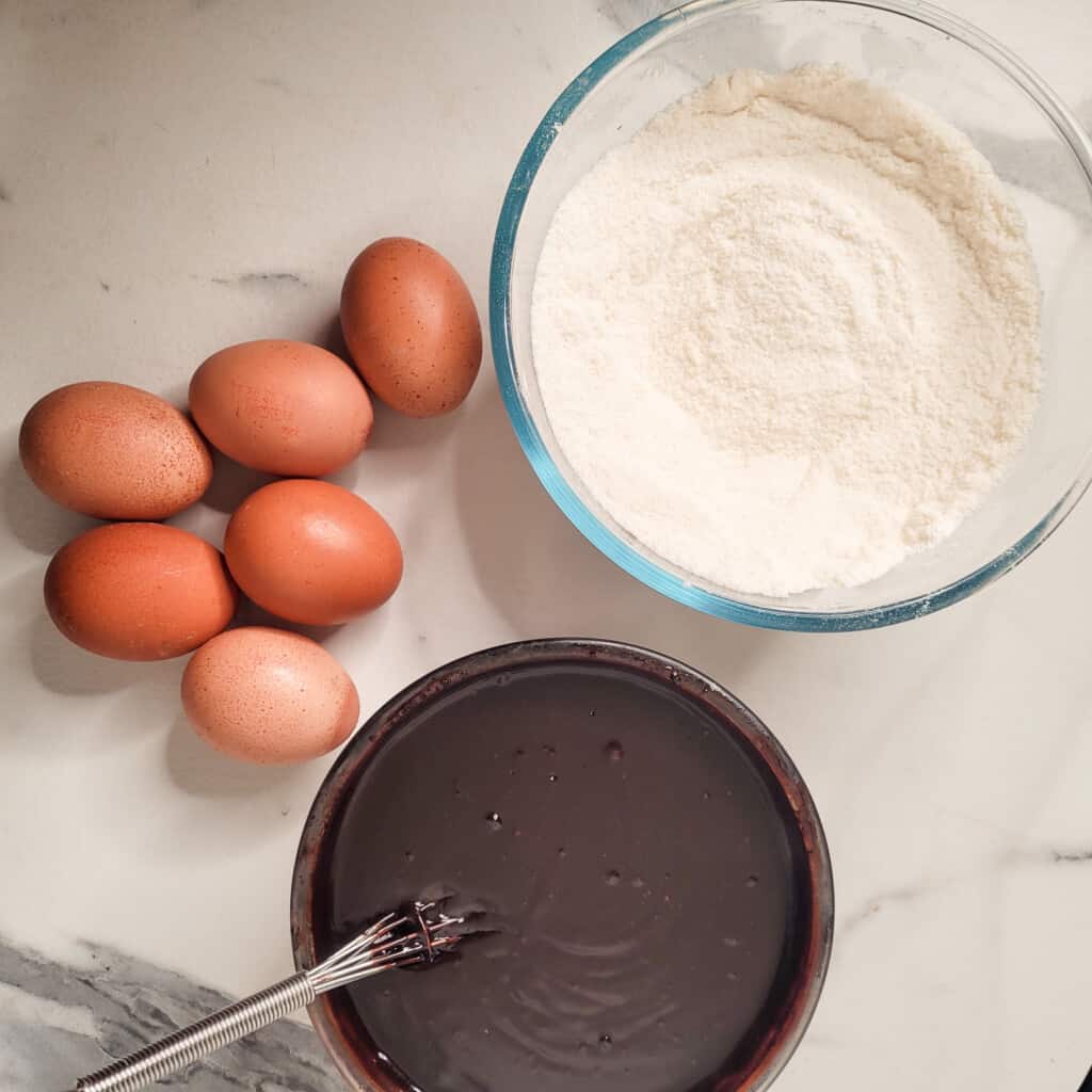 Wet and dry ingredients for mocha brownies with eggs on a table