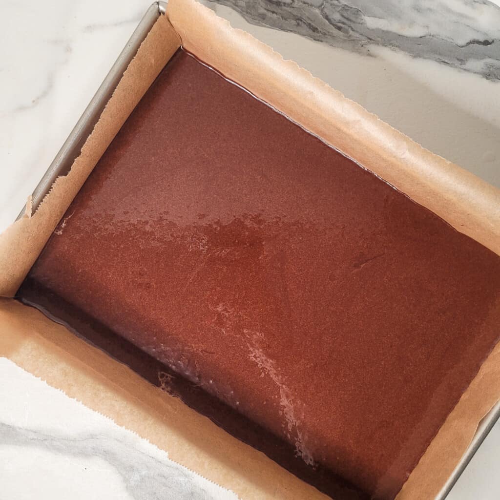 Mocha brownie batter in lined baking sheet