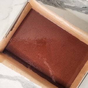 Mocha brownie batter in lined baking sheet