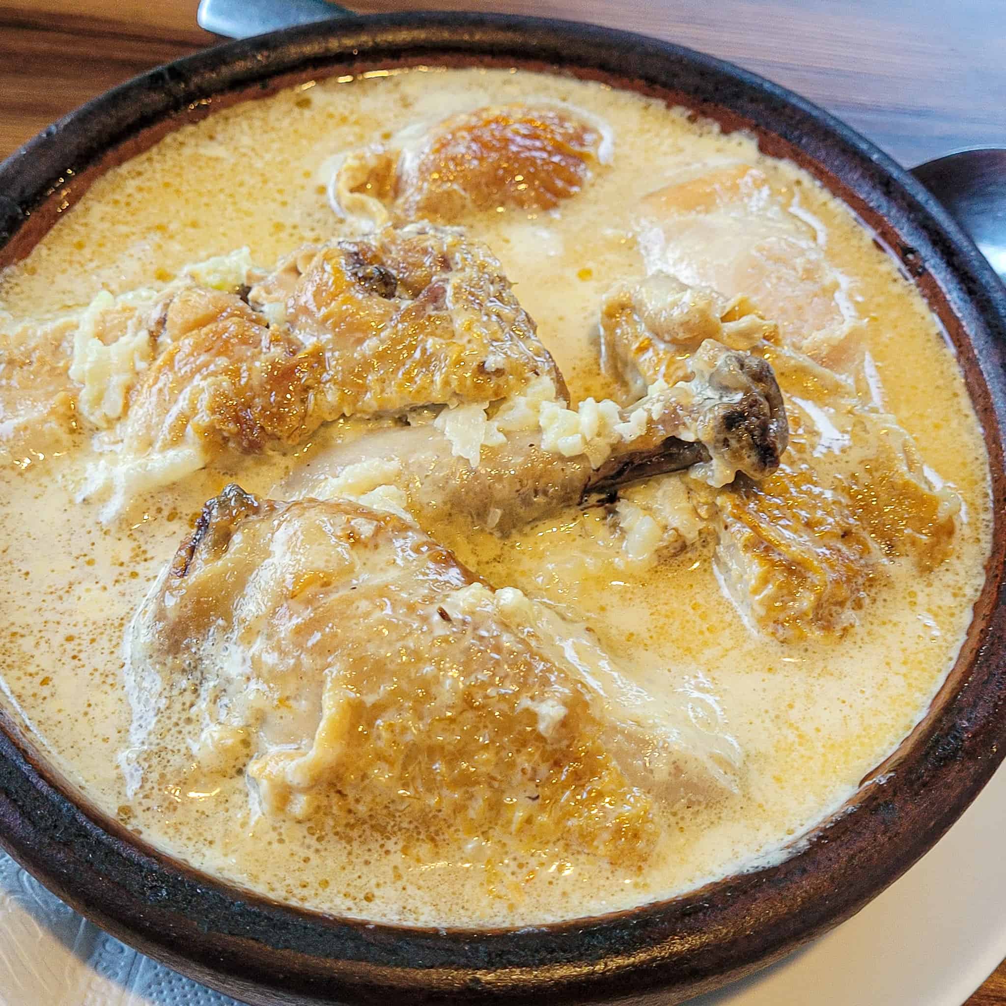 Chkmeruli with white garlic sauce in a clay pan