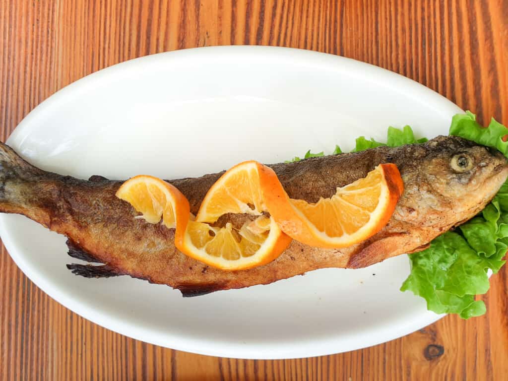 A fried river trout on a white place