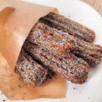Close up of black sesame churros in a paper scone