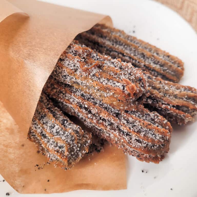 Close up of black sesame churros in a paper scone