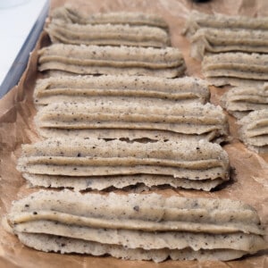 Piped churros in a baking sheet