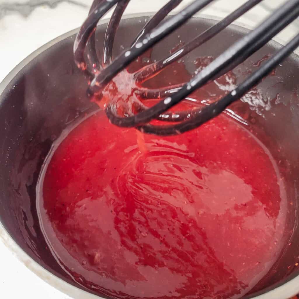 Cooked and thickened strawberry custard pie glaze.