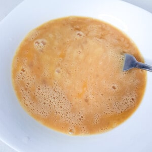 Whisked eggs in a bowl with a fork