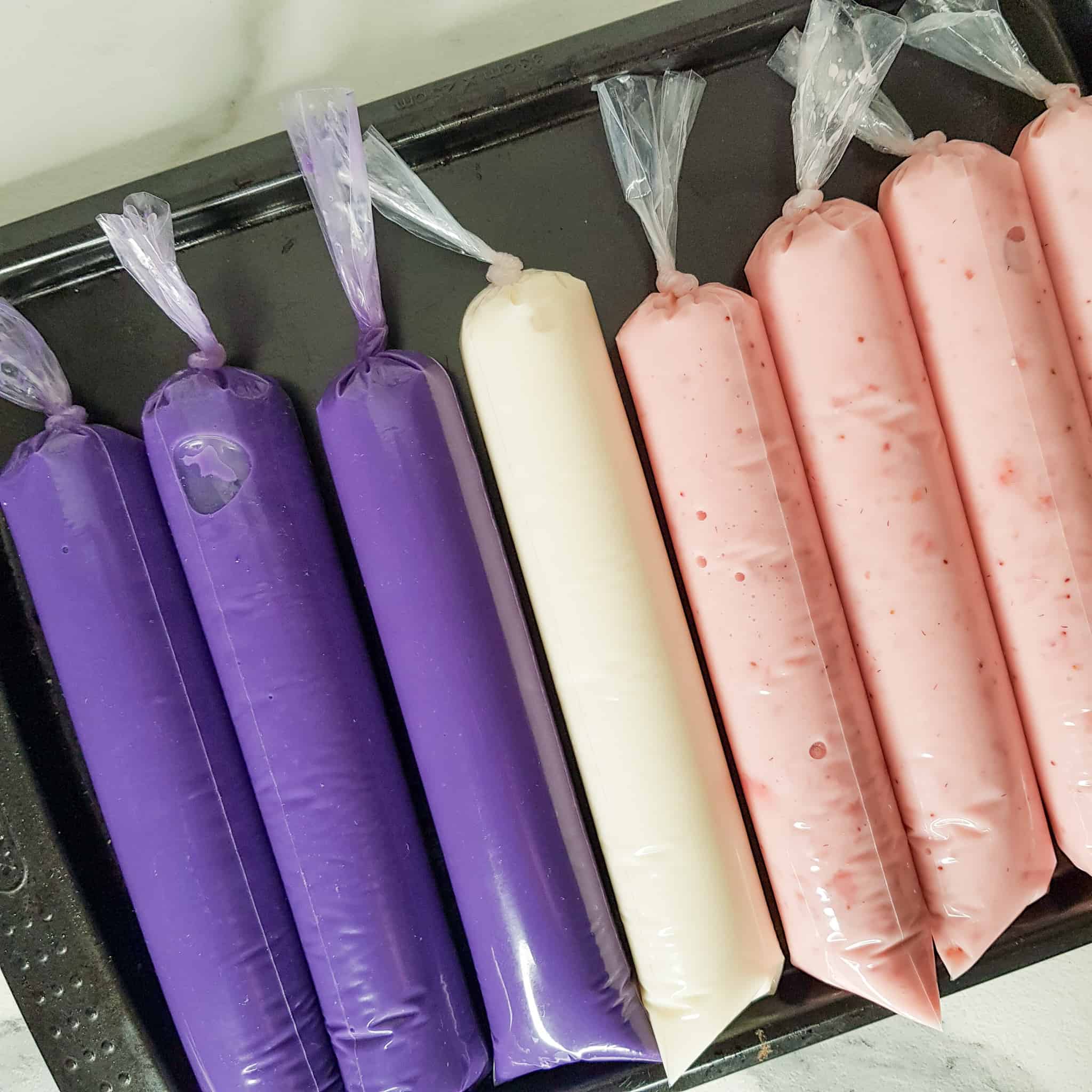Prepared ice candies with ube flavored ones of the left on a baking sheet
