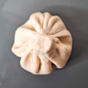 A view of the top of khinkali with a snipped stem.