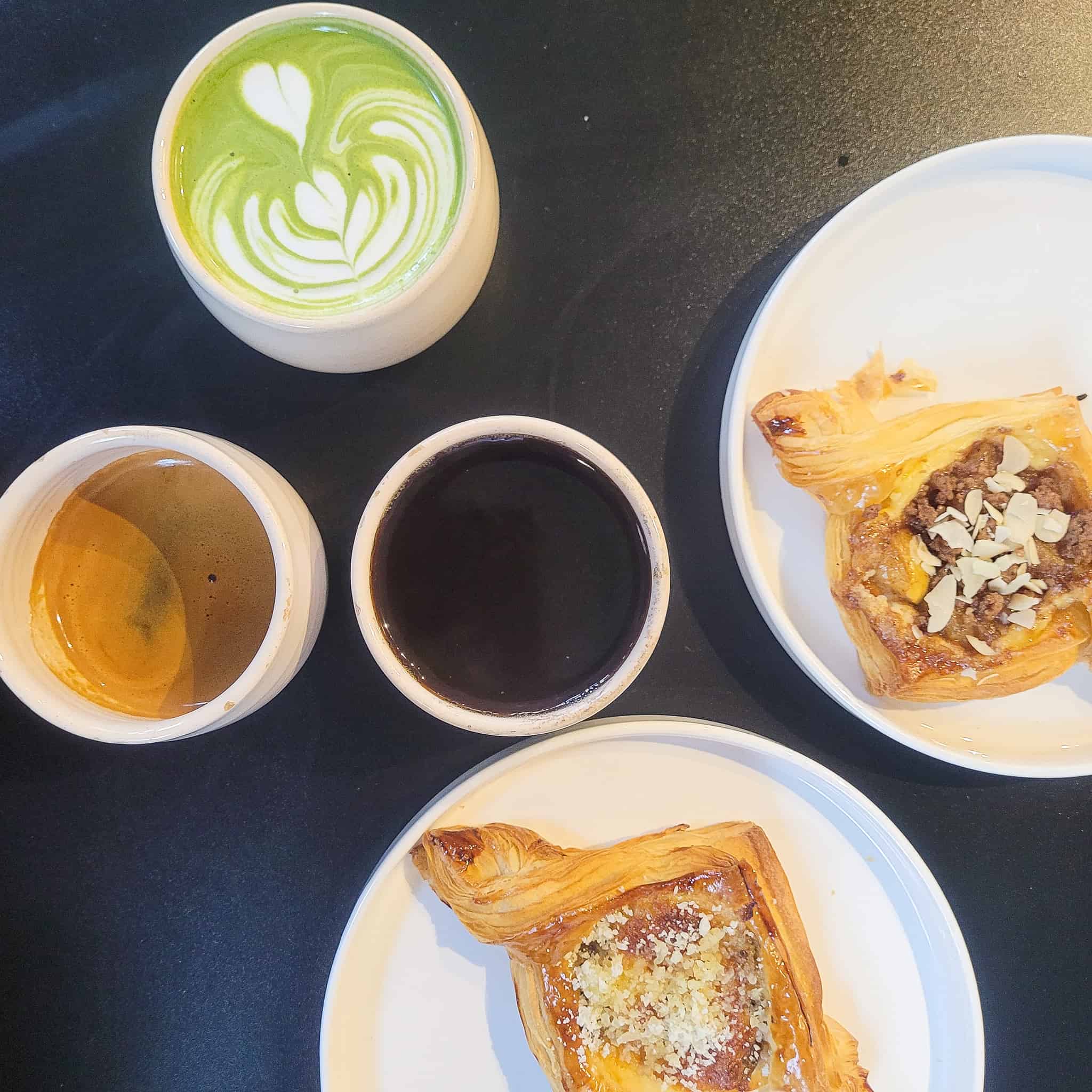 Two types of pastries and mugs of coffee on a table