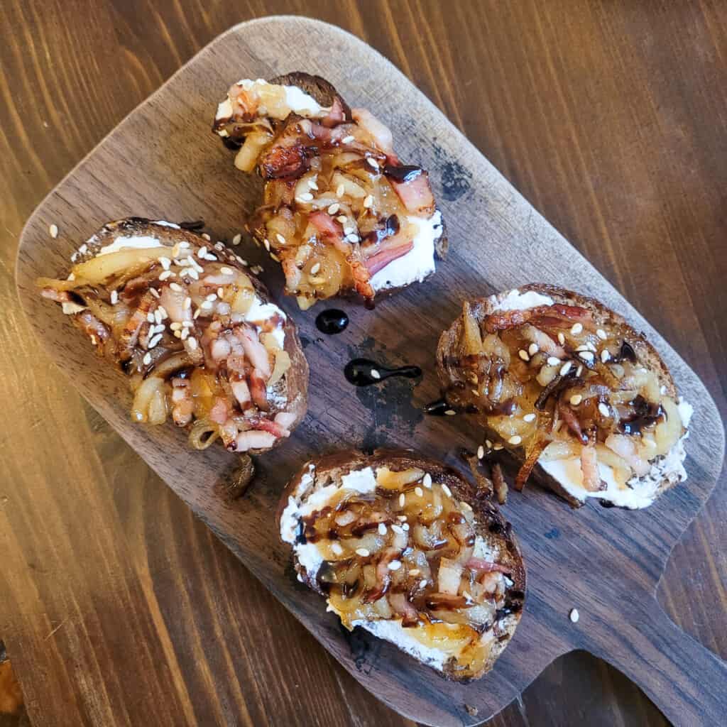 A cutting board with various open-faced sandwiches