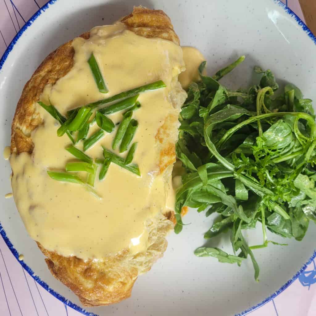 A plate of omelet with a side salad