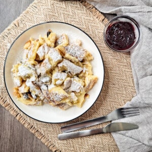 Austrian Kaiserschmarrn or torn pancakes in a white plate on wooden surface