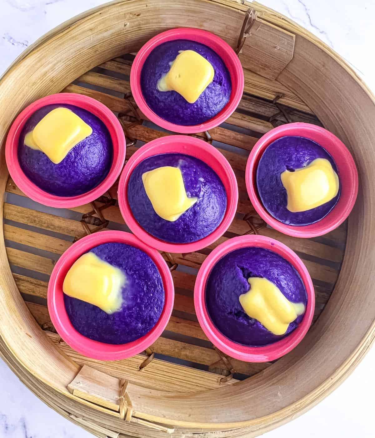 A wooden steamer filled with ube rice cakes called ube puto