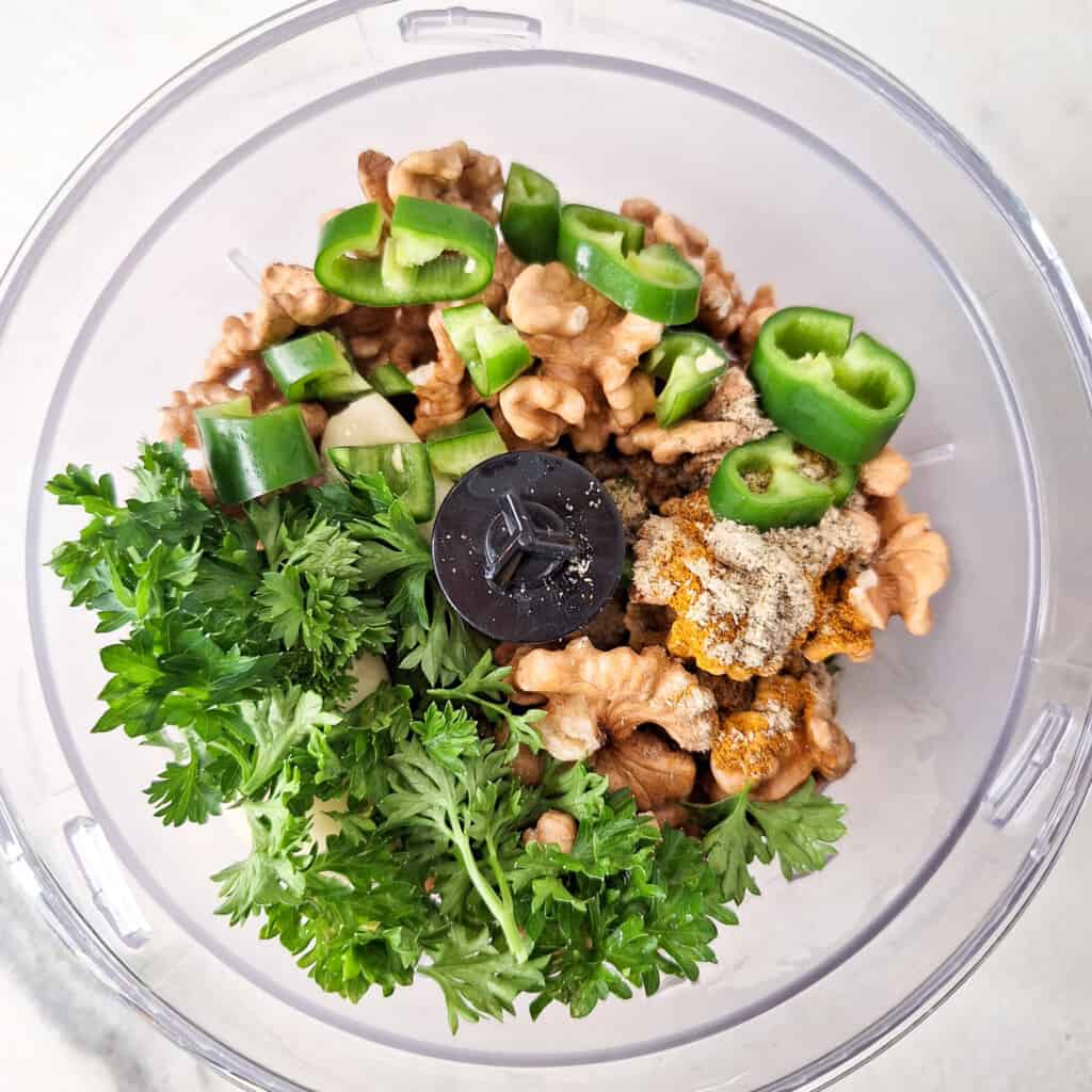 whole walnuts, parsley, chopped chilies, and seasonings in a food processor