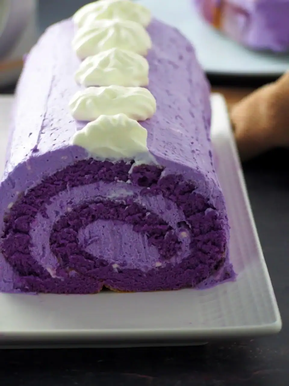 The front swirl of an ube roll cake on a white plate