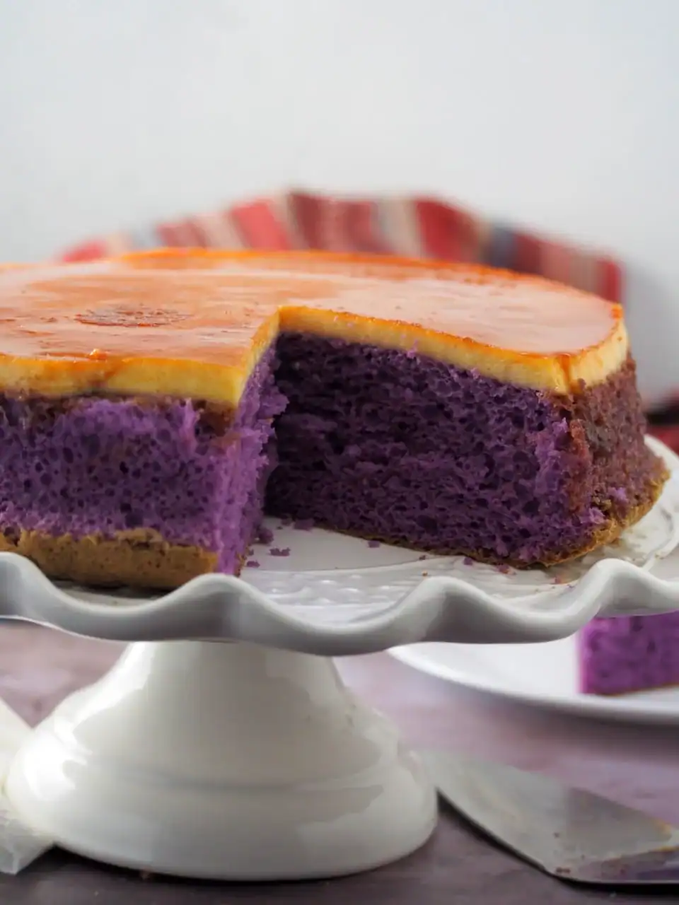 Cross-section of ube flan cake on a cake holder