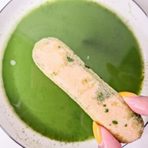 Dipping ladyfingers in a bowl of matcha green tea