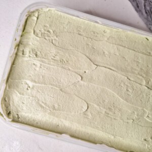 Smooth matcha whipped cream for tiramisu in a container