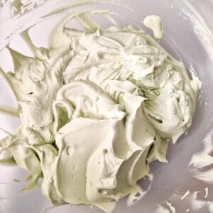Thickened heavy cream with matcha powder in a plastic bowl