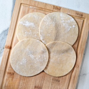 Empanada dough pieces on a wooden board