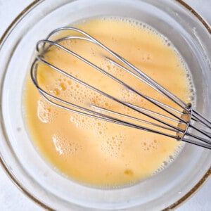 Clear bowl with whisked eggs and water