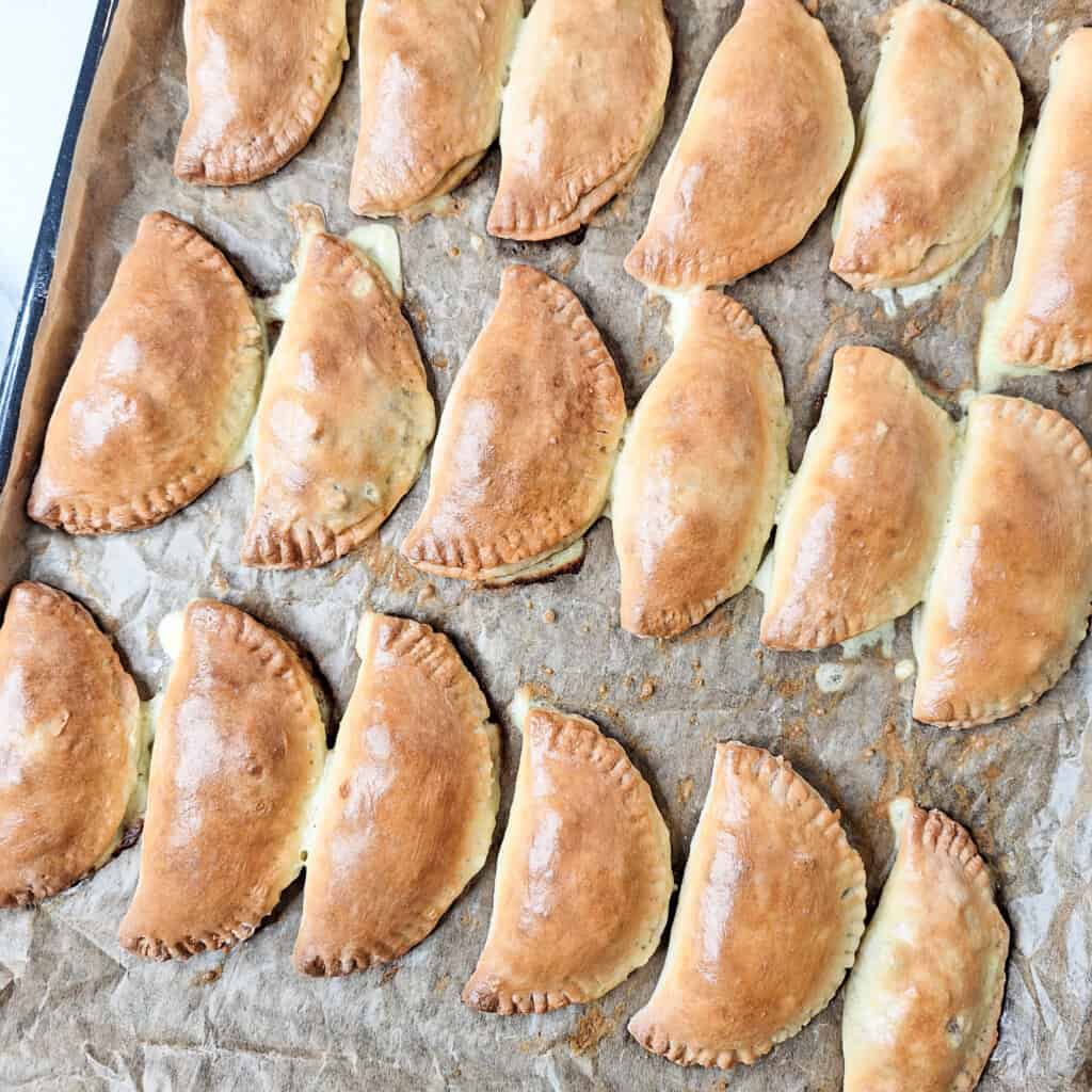 A baking sheet with baked empanadas