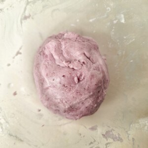 Ube glutinous rice dough in a plastic bowl