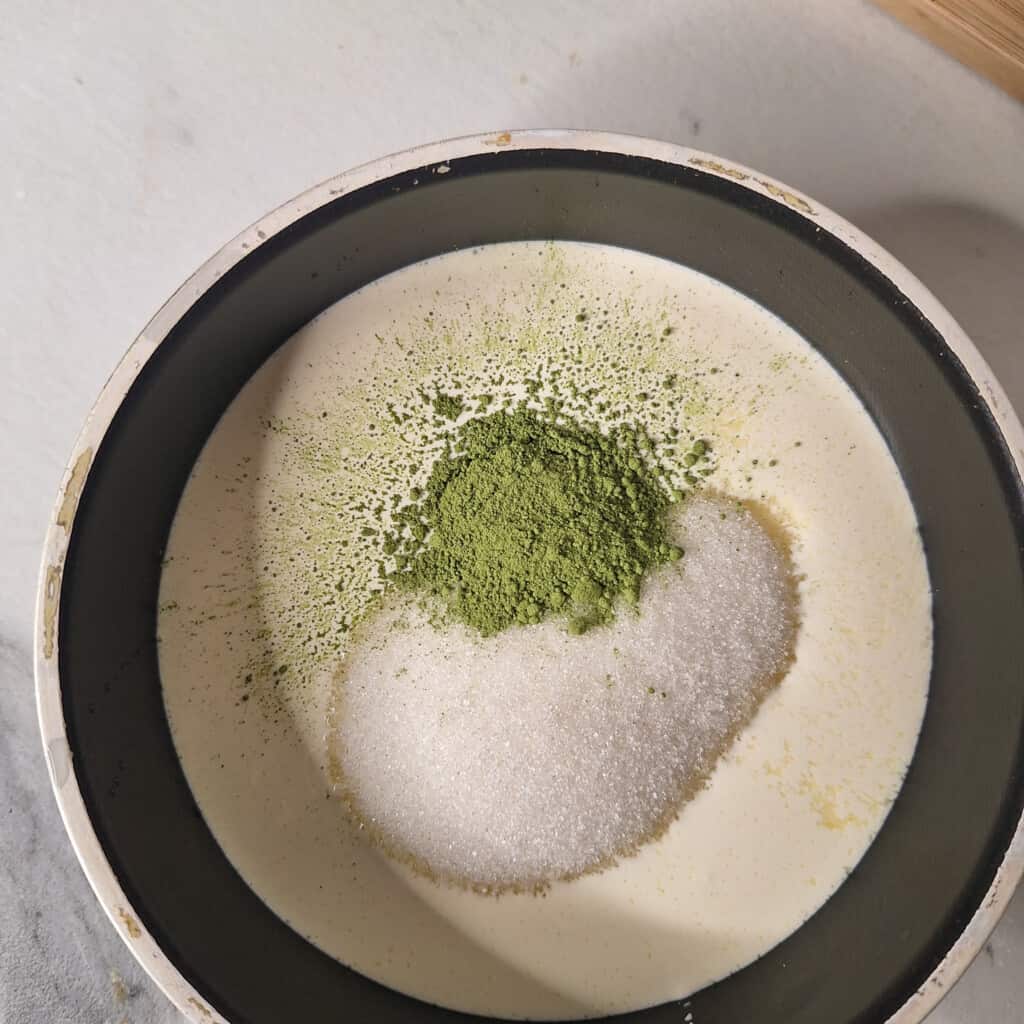 Matcha powder, heavy cream, and sugar in a small pot