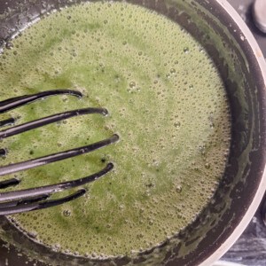 Mixed matcha, heavy cream, and sugar in a black pot