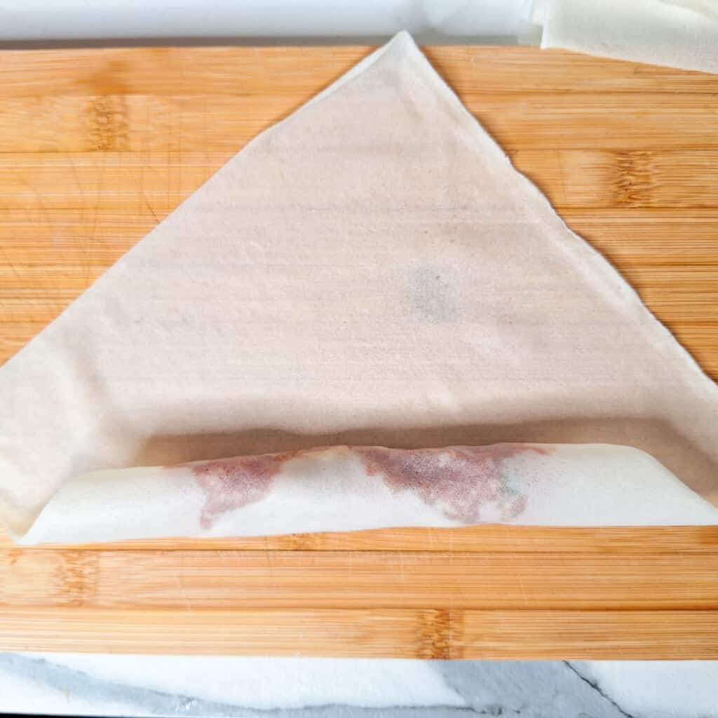 Filipino spring roll or lumpia in process of rolling