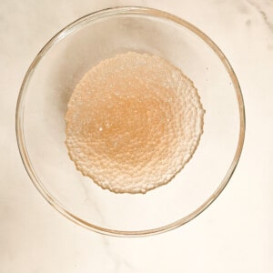 A glass bowl filled with thoroughly cooked sago or tapioca balls