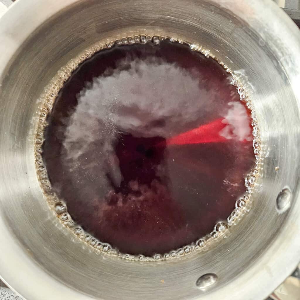 Boiling water and brown sugar syrup in a stainless steel pot for taho
