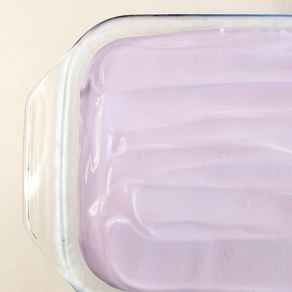 Ube whipped cream in a glass baking dish