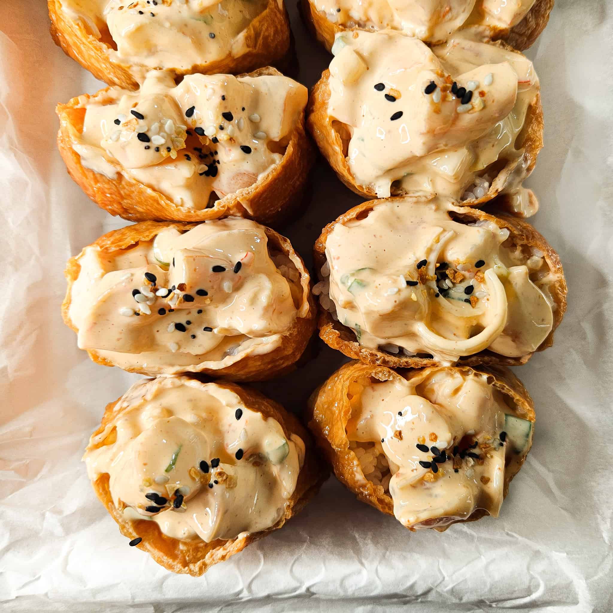 Close up of shrimp inari sushi with black sesame seeds