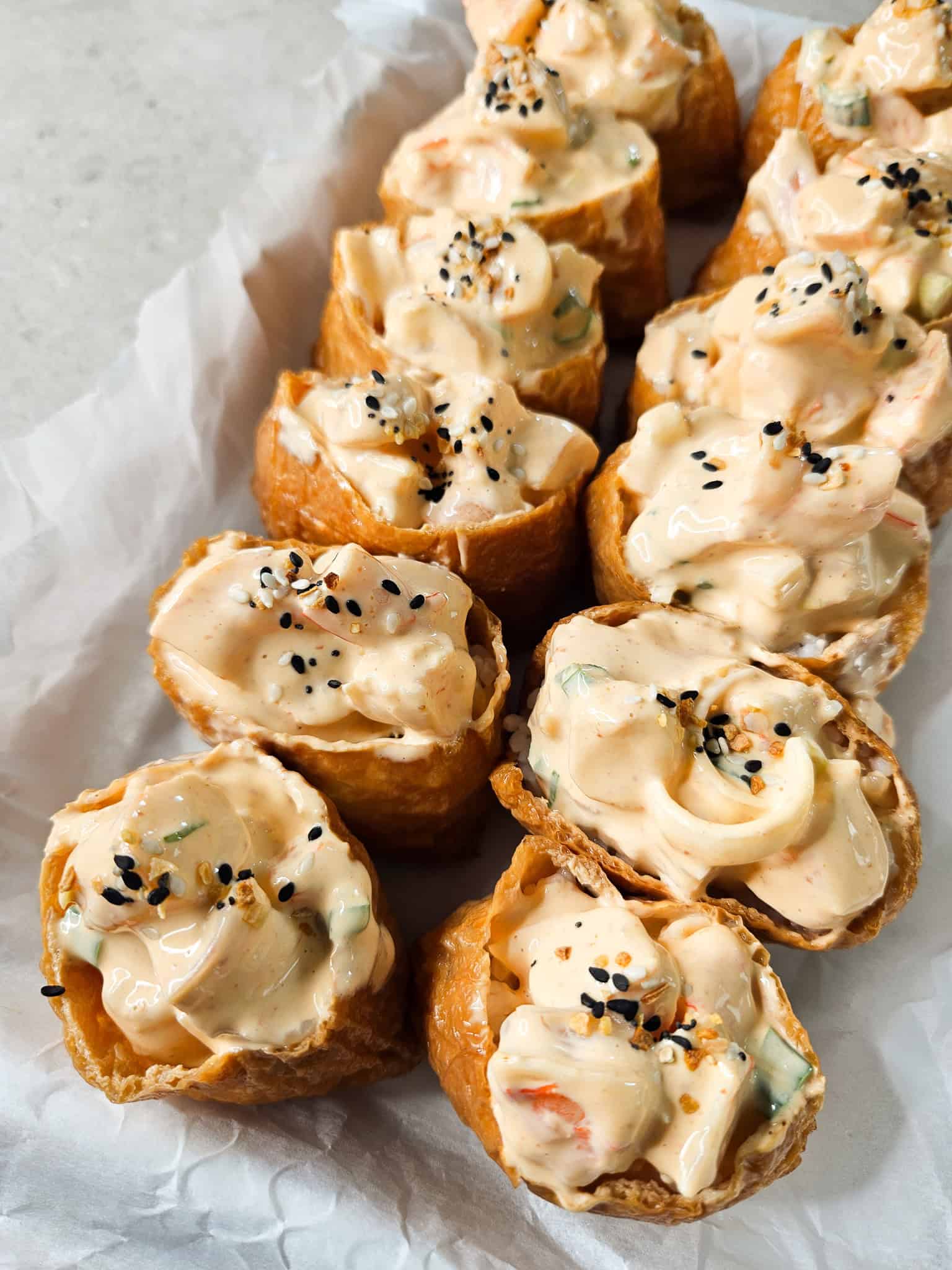 Shrimp inari sushi lined up on a line baking sheet