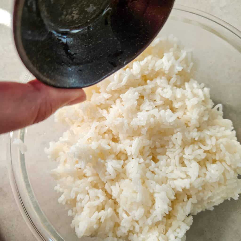 White rice in a bowl with vinegar and sugar mixture