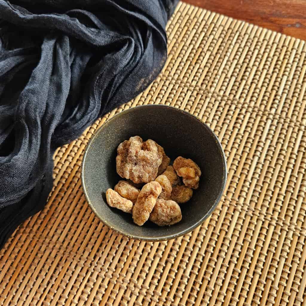 Pieces of cinnamon walnuts inside a ceramic bowl