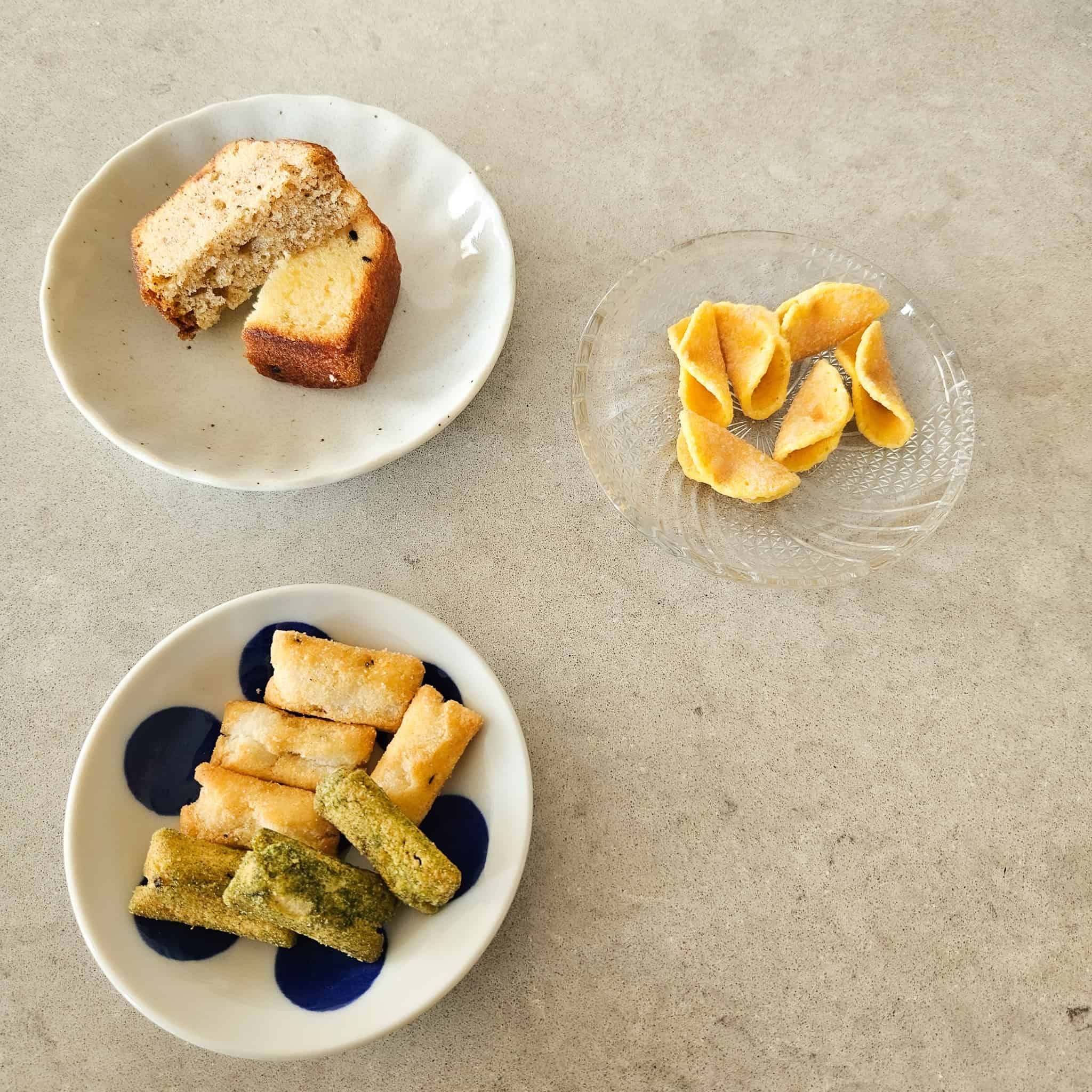 Three small plates with assorted Japanese snacks